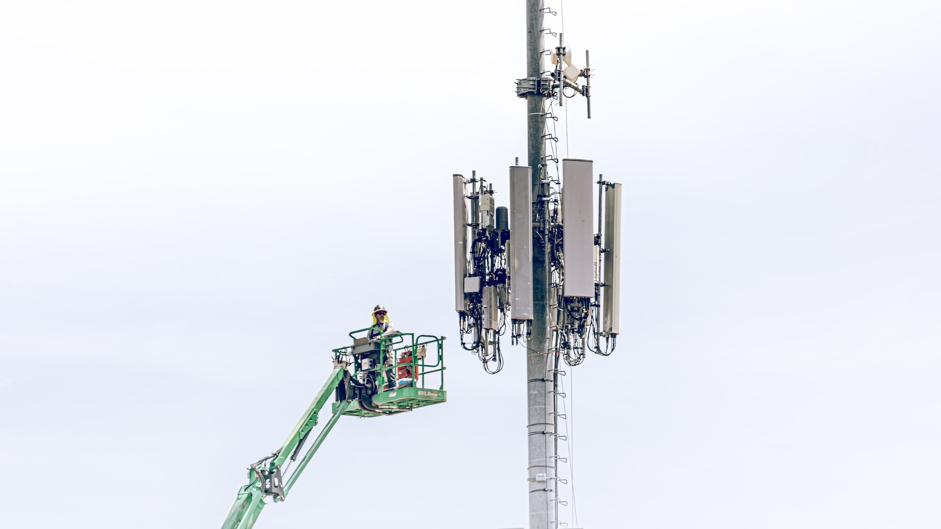 a man on a lift working on a cell phone tower